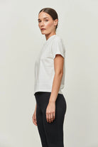 Model wearing a white box tee The Aiton by Greyven