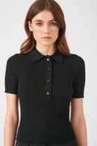 Model wearing the Black Emma Luxe Polo, showcasing its modern fit and elegant crepe fabric.