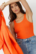 Model wearing the Orange Crush Gillian Knit Tank, showcasing its vibrant color and intricate pointelle design.